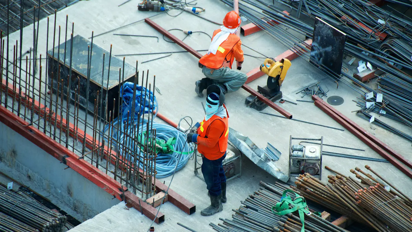 Bouwvakkers aan het werk tussen de wapening, van bovenaf