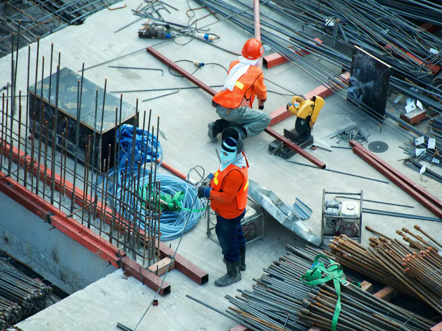 Bouwvakkers aan het werk tussen de wapening, van bovenaf