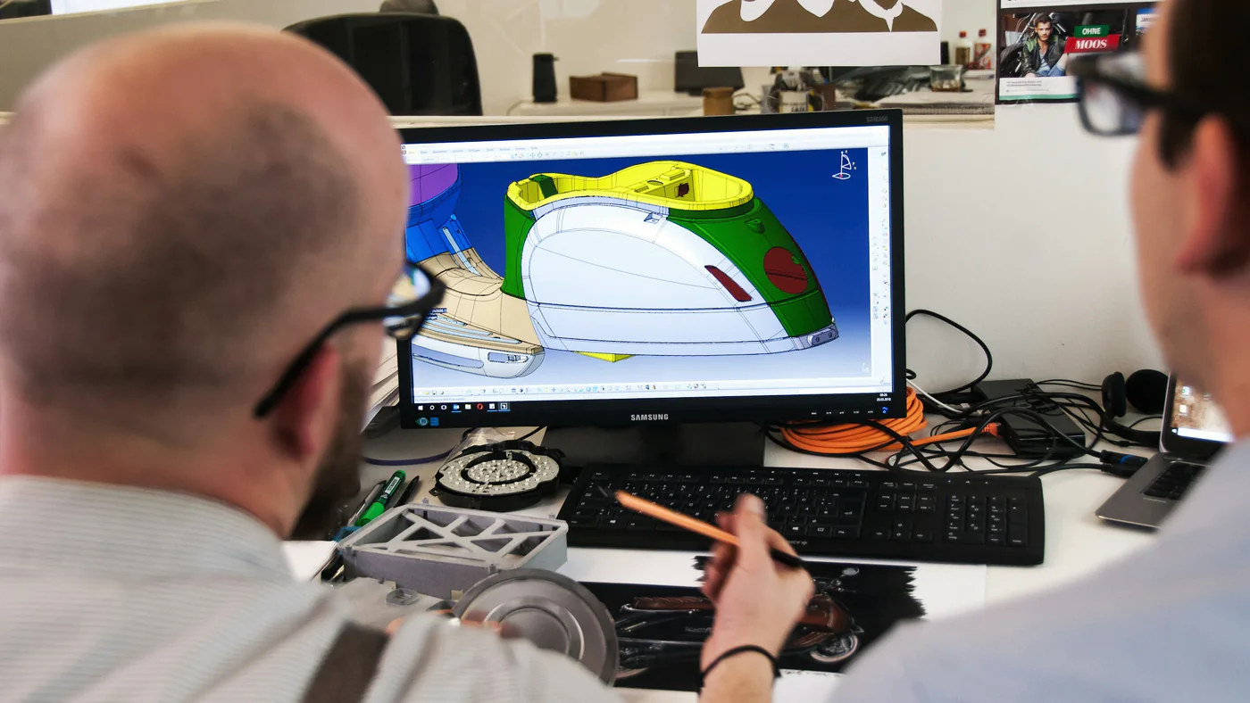 Twee engineers bespreken een 3D-ontwerp op het scherm