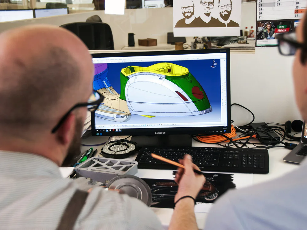 Twee engineers bespreken een 3D-ontwerp op het scherm