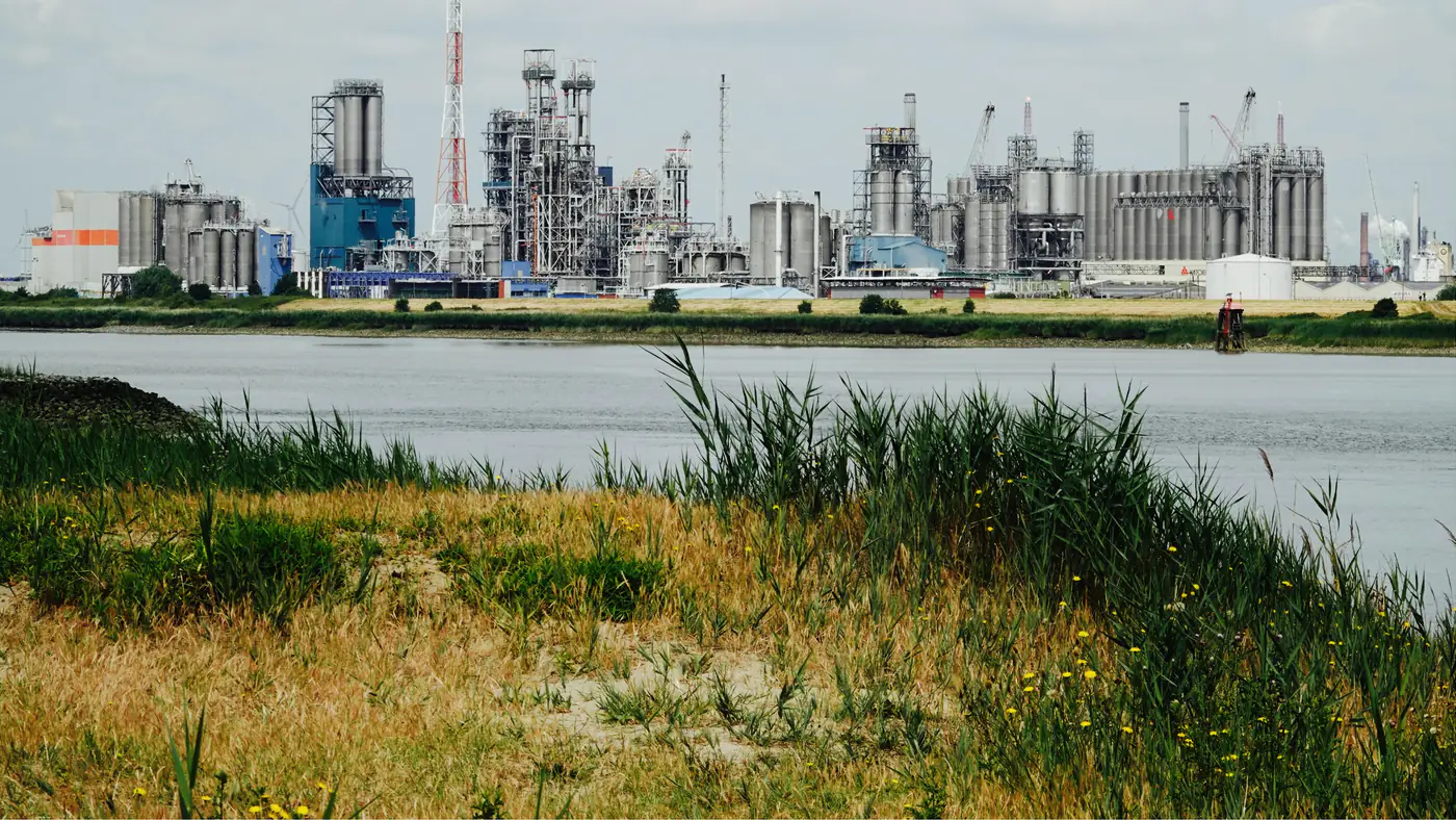 Chemisch complex aan het water, gezien vanaf de oever