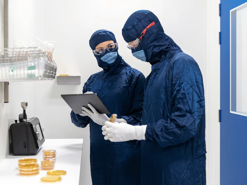 Twee medewerkers in cleanroomkleding met een tablet