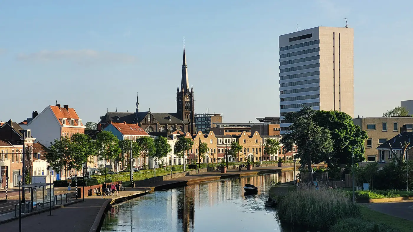 Gracht in Delft met kerktoren en een hoog universiteitsgebouw