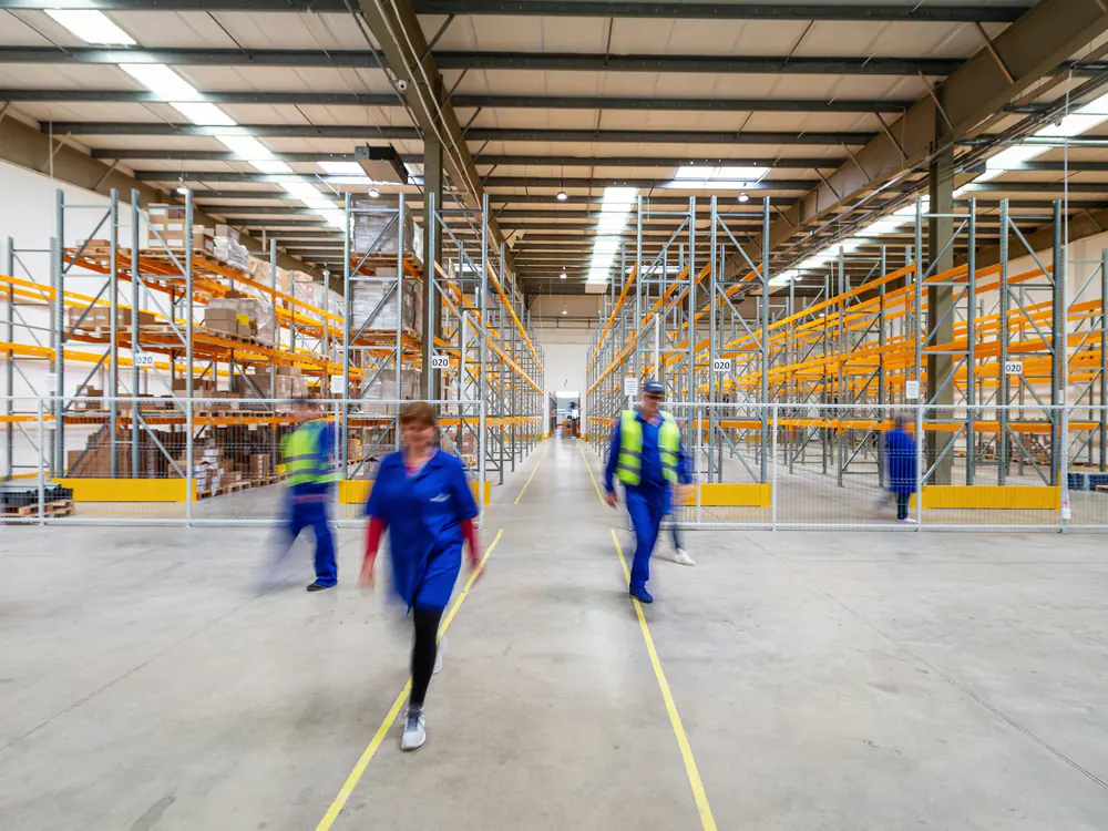 Medewerkers lopen door een groot distributiecentrum
