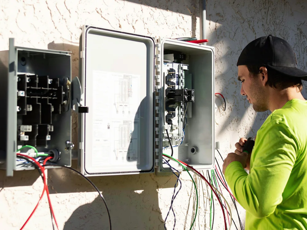 Elektromonteur bij een geopende verdeelkast buiten