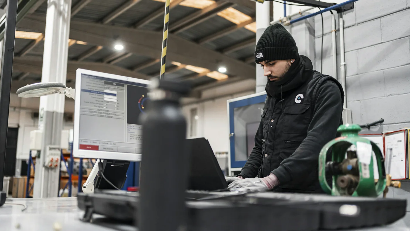 Engineer werkt op een laptop in een werkplaats