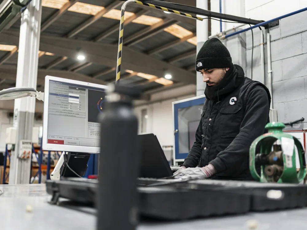 Engineer werkt op een laptop in een werkplaats