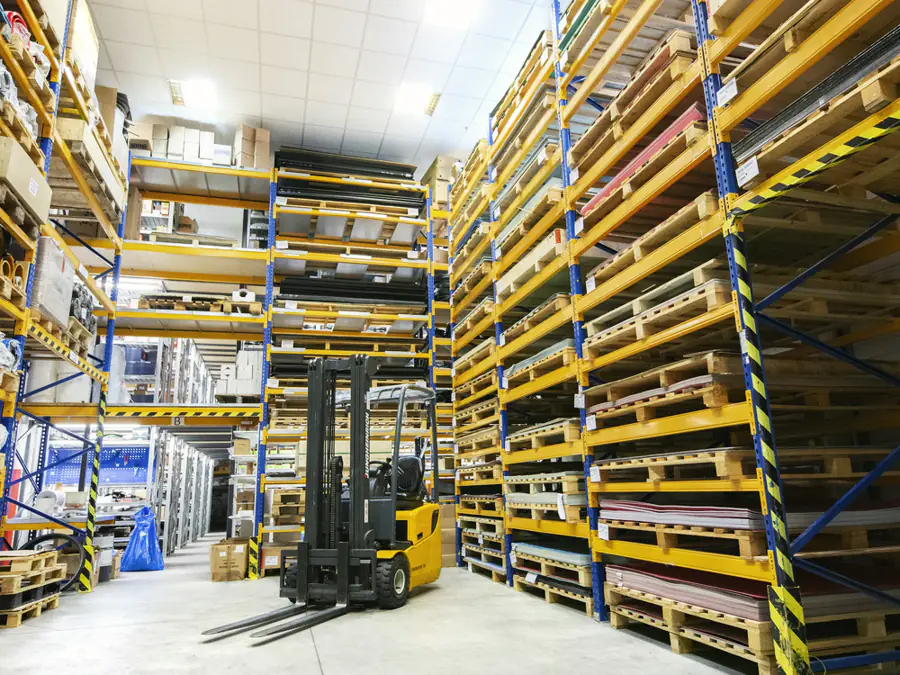 Heftruck in een magazijn met hoge stellingen