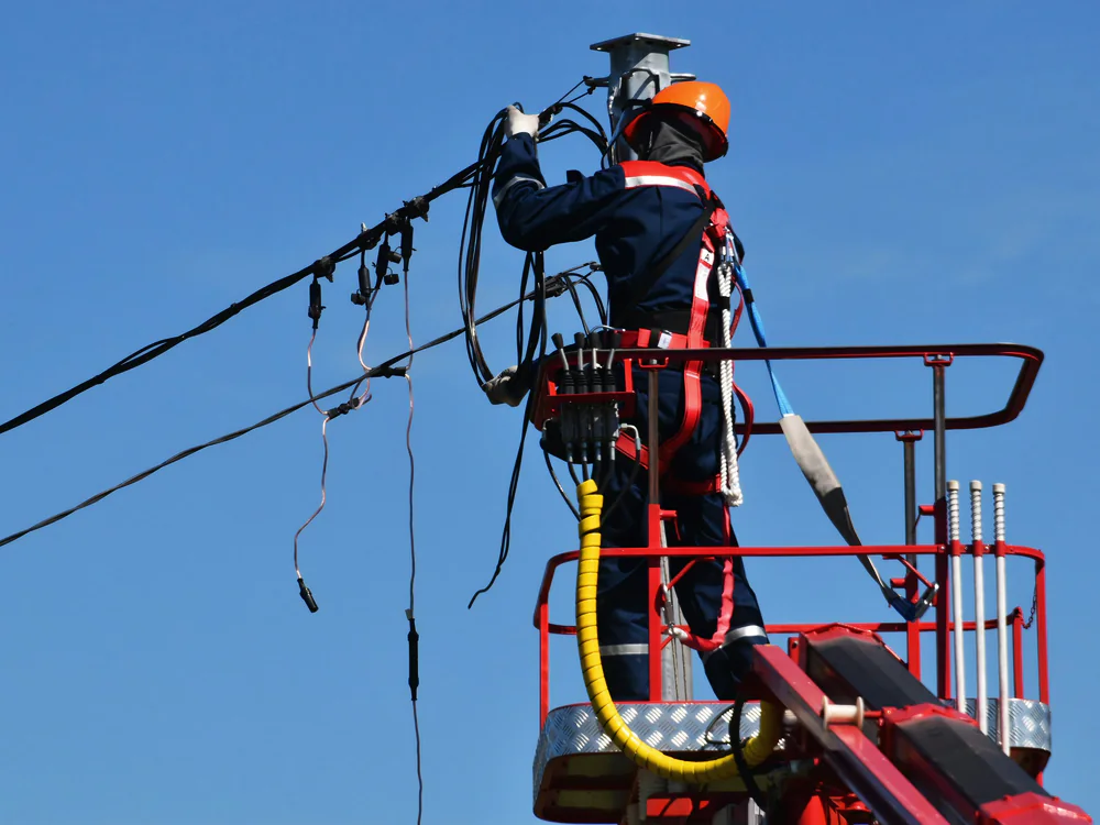 Monteur in een hoogwerker werkt aan elektriciteitskabels