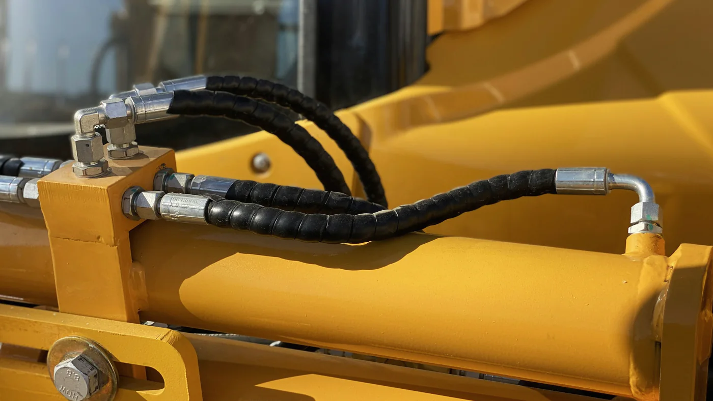 Hydraulische slangen en cilinder op een gele machine