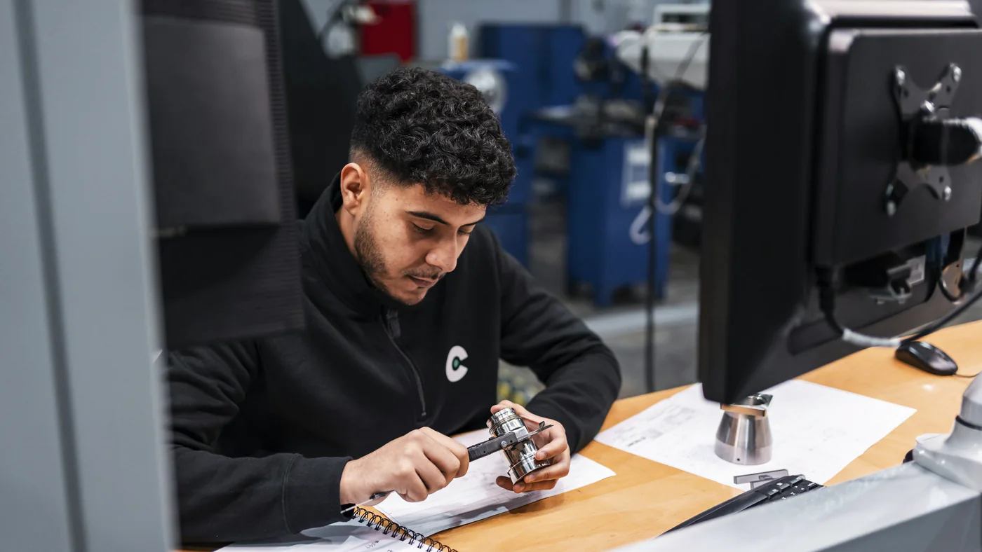 Technicus meet een onderdeel na aan een werkplek