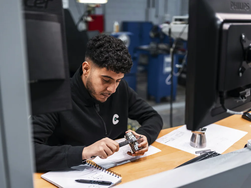 Technicus meet een onderdeel na aan een werkplek