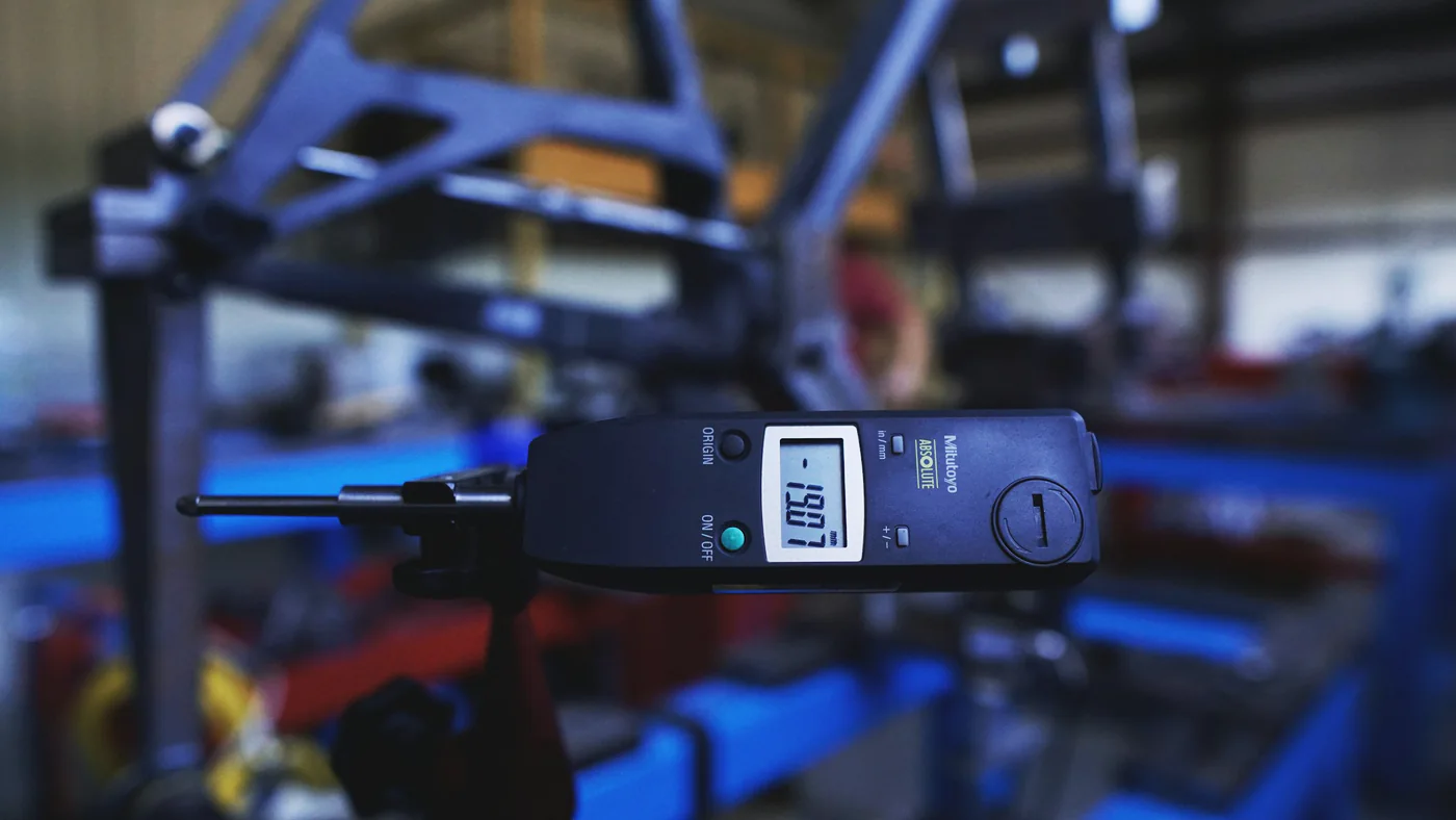 Digitaal meetinstrument tussen blauwe machineonderdelen