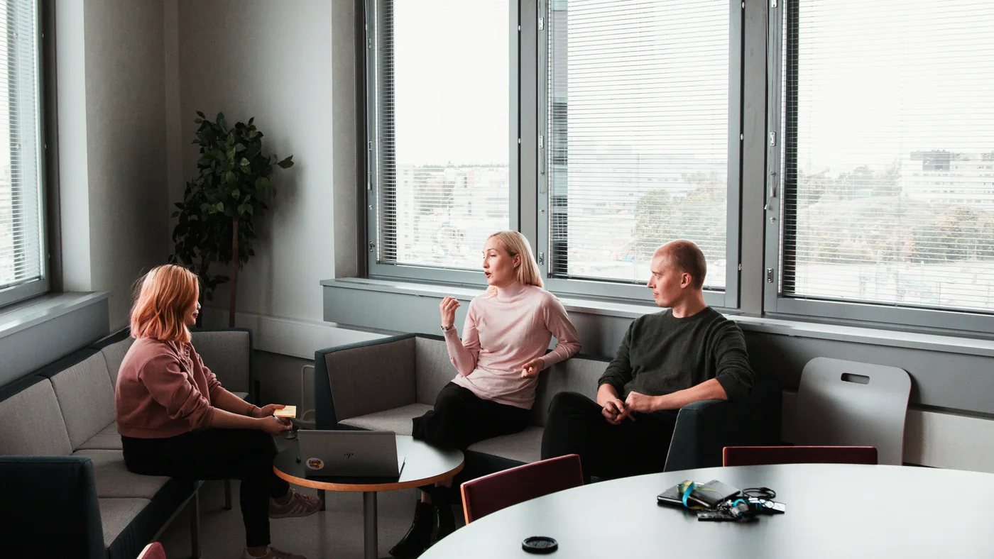 Drie collega's overleggen in een kantoor met uitzicht