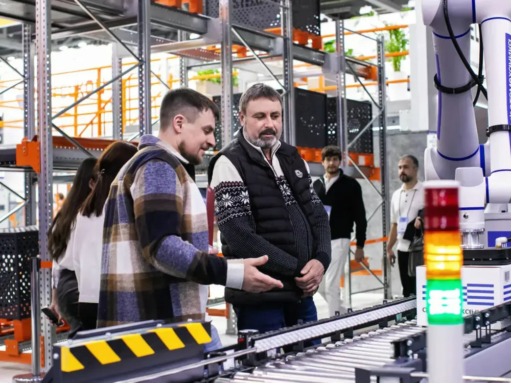 Twee mannen overleggen naast een geautomatiseerde productielijn