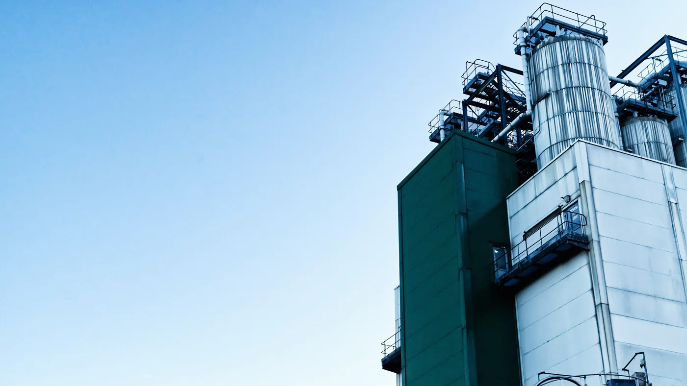 Procesinstallatie met silo's tegen een blauwe lucht