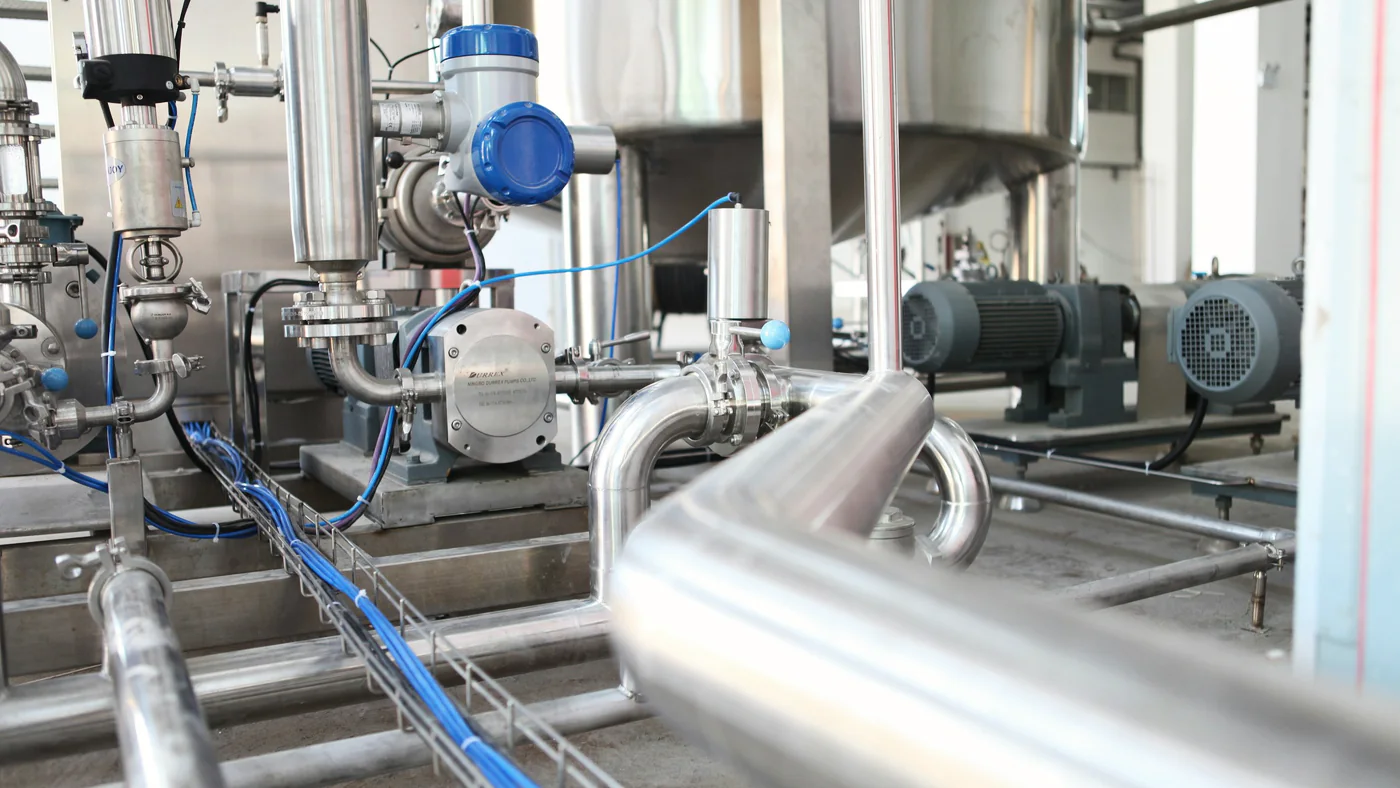 RVS-procesleidingen en pompen in een productieruimte