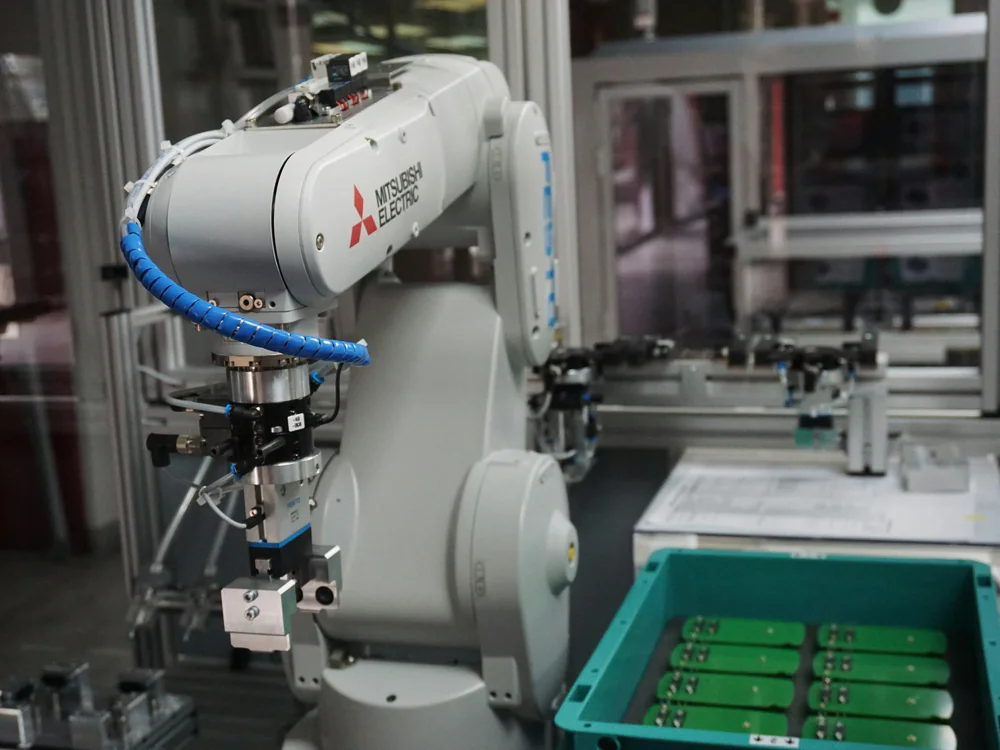 Industriele robot pakt printplaten uit een krat