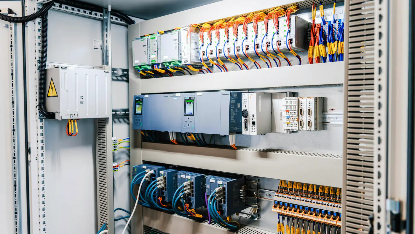 Geopende industriele schakelkast met PLC, relais en nette bedrading