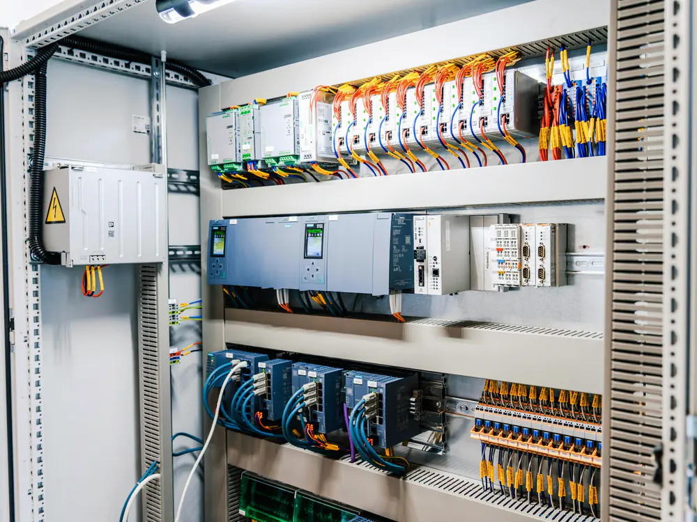 Geopende industriele schakelkast met PLC, relais en nette bedrading