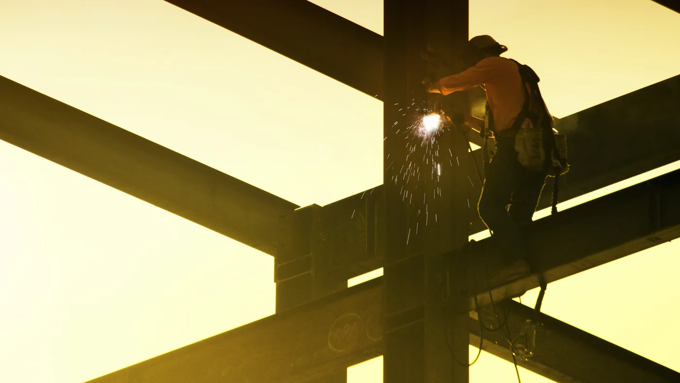 Constructiebankwerker last op hoogte aan een stalen balk