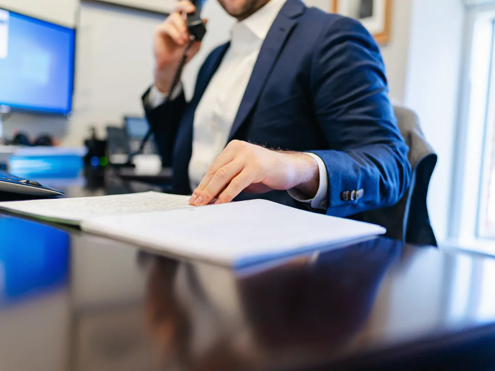 Man belt aan een bureau met documenten