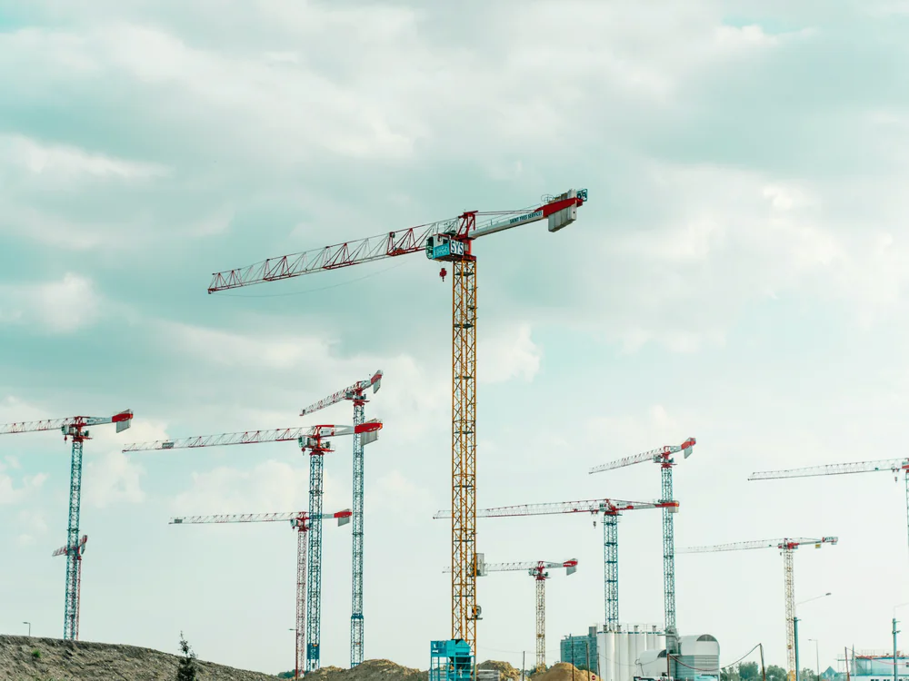Meerdere torenkranen boven een groot bouwterrein