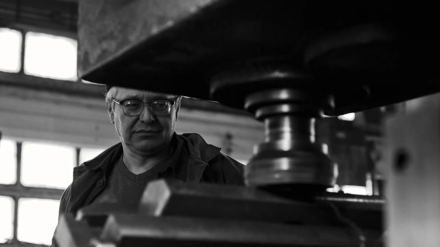 Vakman aan een machine, in zwart-wit