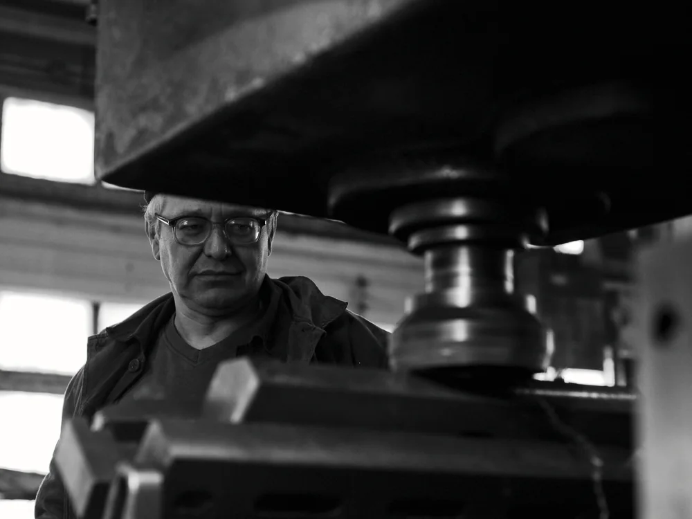 Vakman aan een machine, in zwart-wit