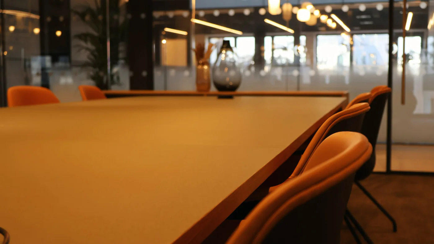 Vergadertafel met lederen stoelen in een kantoor met veel glas