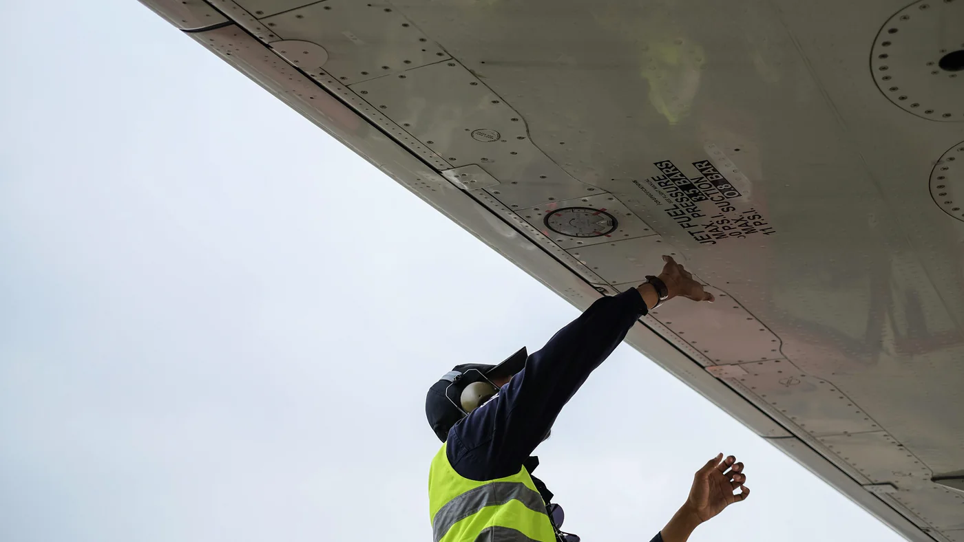 Technicus inspecteert de vleugel van een vliegtuig