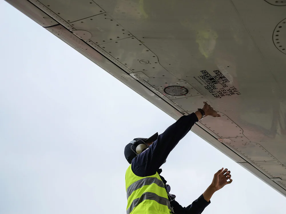 Technicus inspecteert de vleugel van een vliegtuig