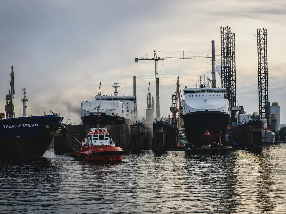 Schepen en een hefplatform aan de kade van een werf