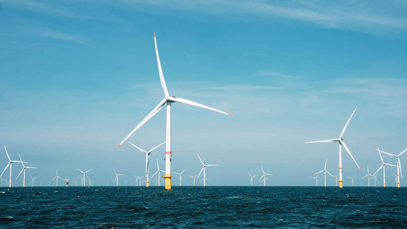 Windturbines op zee onder een blauwe lucht