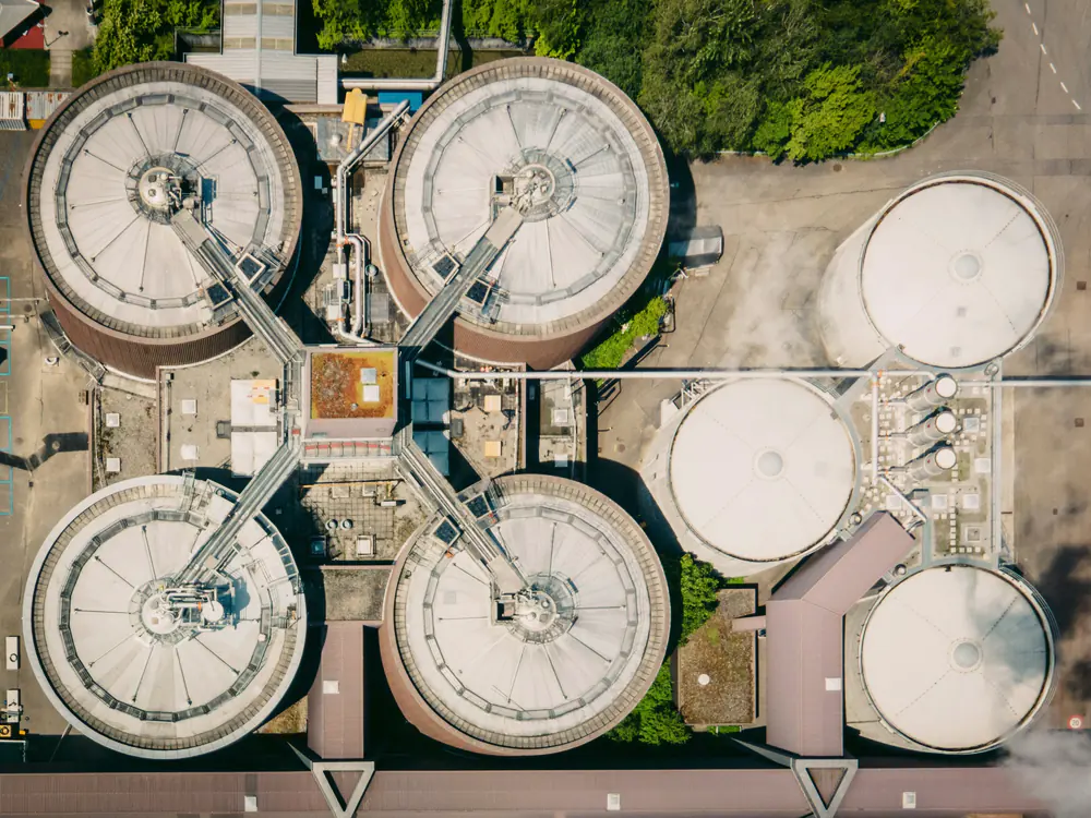 Ronde tanks van een rioolwaterzuivering van bovenaf